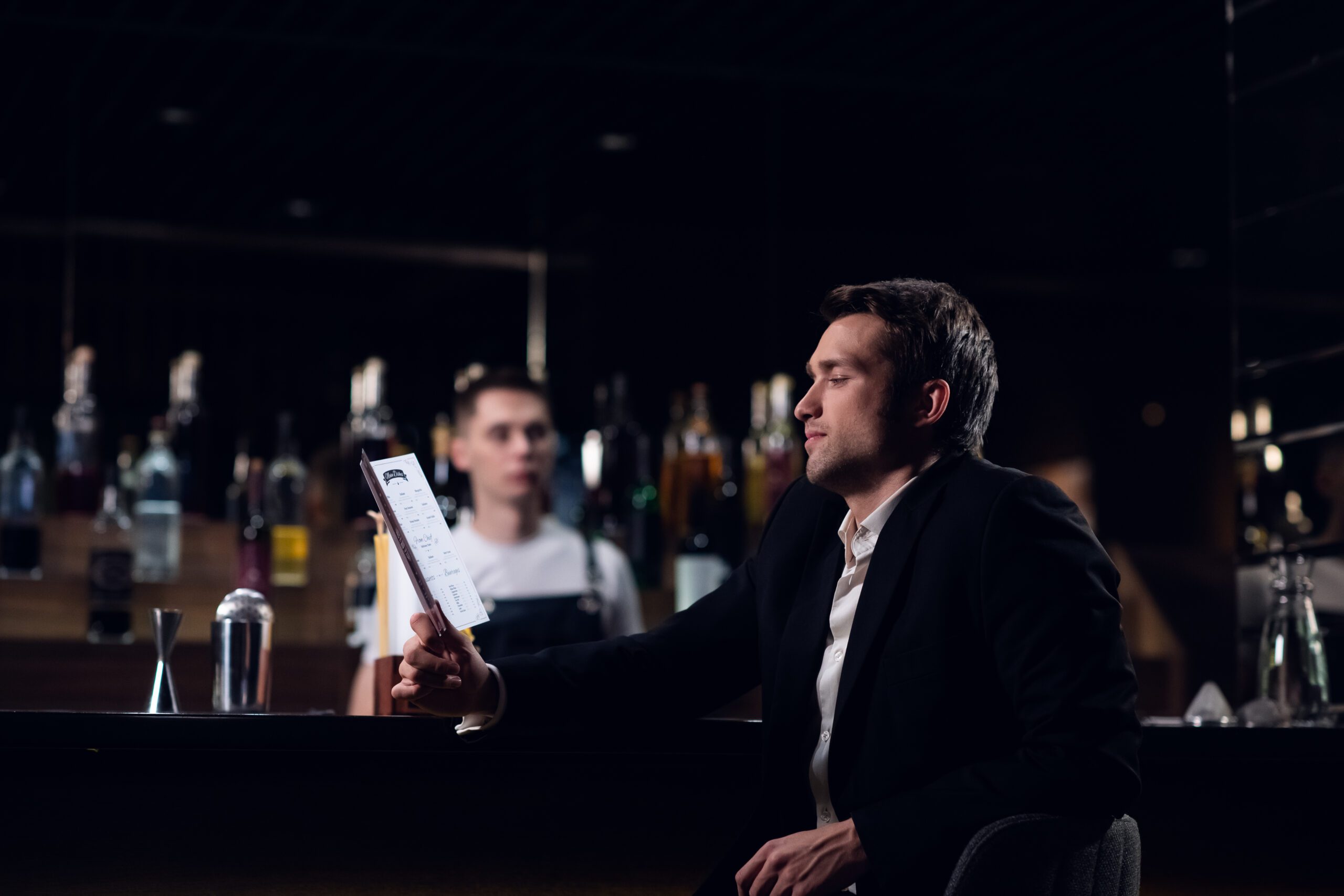 man reading menu at a bar