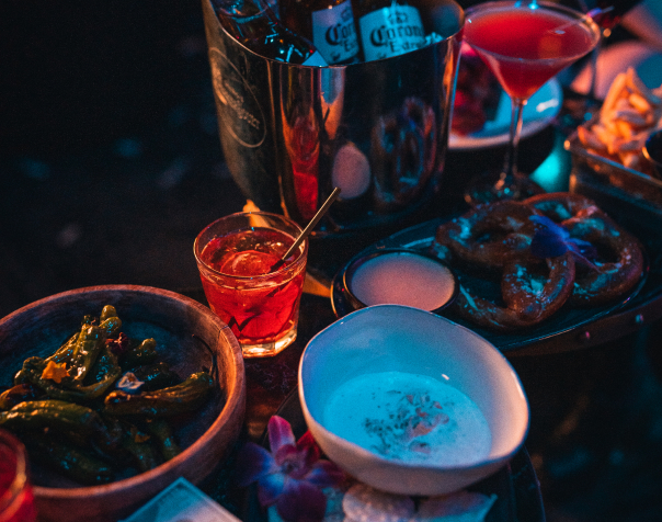 Plates of food and drinks on a table at a VIP party.